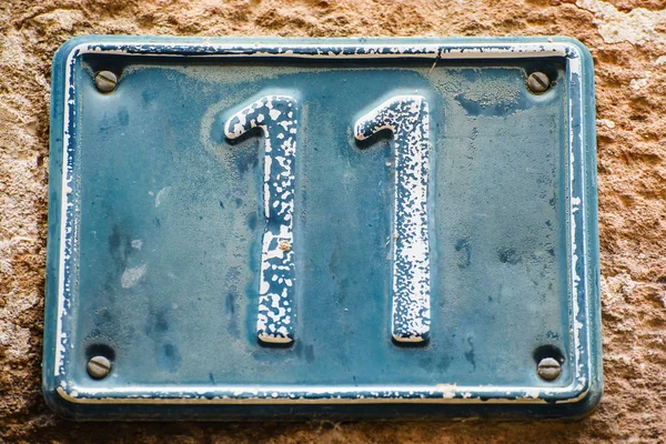 Bord met nummer elf op oude muur — Stockfoto
