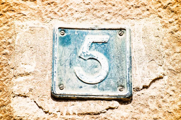 Skylt med nummer fem på den gamla muren — Stockfoto