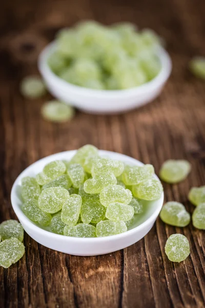 Houten tafel met zure gummy snoepjes — Stockfoto