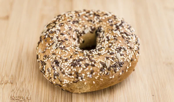 Tavolo in legno con bagel integrali appena sfornati — Foto Stock