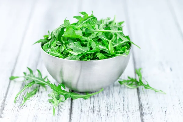 Tavolo in legno con Arugula fresca — Foto Stock