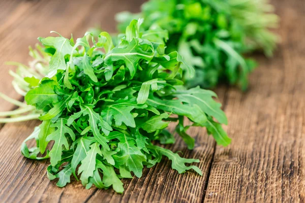 Frischer Rucola auf einem alten Holztisch — Stockfoto