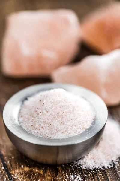 Houten tafel met roze zout — Stockfoto