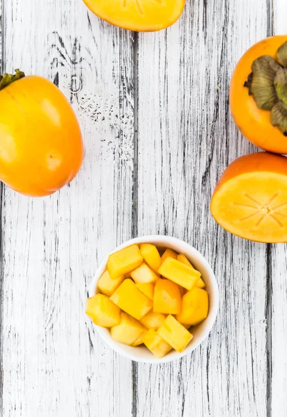 Kaki fruit on rustic wooden background — Stock Photo, Image