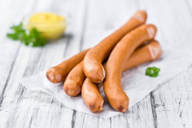 Sausages on wooden background clipart