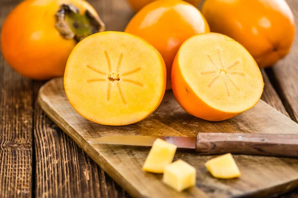 Fruta kaki em fundo de madeira rústica — Fotografia de Stock