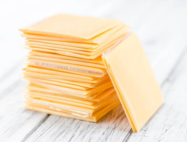 Cheese slices on wooden table — Stock Photo, Image