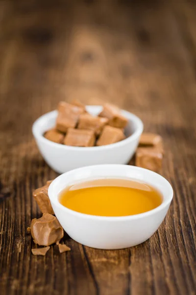 Xarope de caramelo e doces em taças — Fotografia de Stock