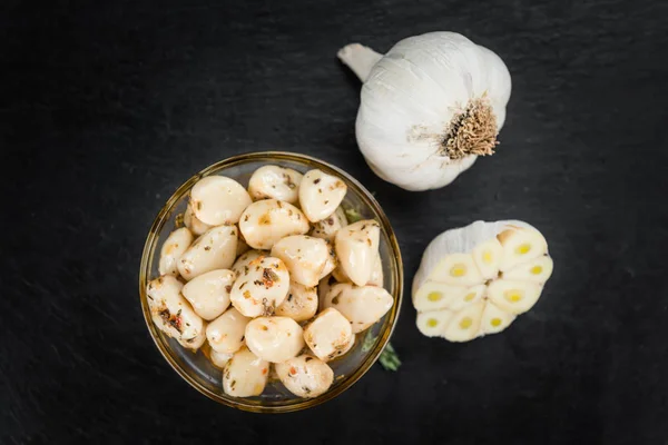 Marinerad vitlök på ett gammalt träbord — Stockfoto