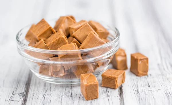 Pedaços de caramelo em fundo de madeira — Fotografia de Stock