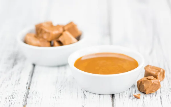 Caramel Sauce on wooden background (selective focus) — Stock Photo, Image