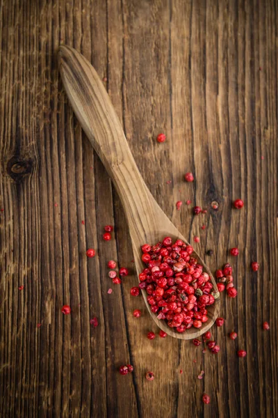 Peppercorns on an old wooden table — Stock Photo, Image