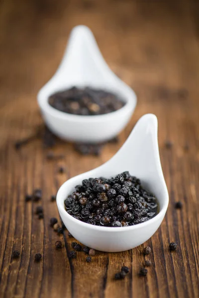 Table avec conserves de grains de poivre noir — Photo