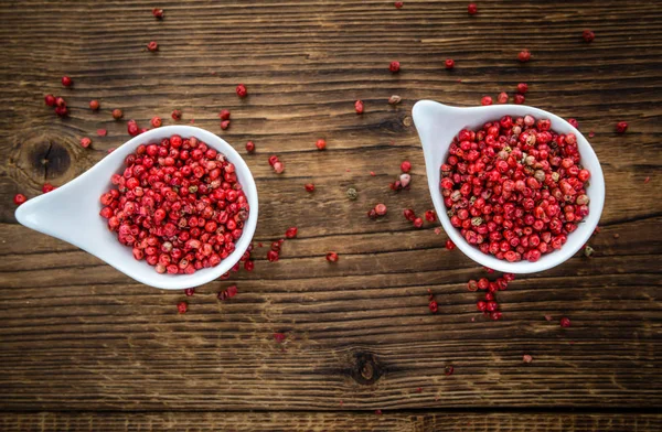 Peppercorns on an old wooden tabl — Stock Photo, Image