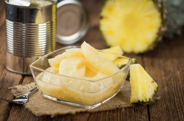 Tavolo in legno con anelli di ananas conservati — Foto Stock