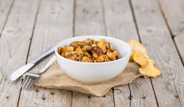 Fresh made Fried Chanterelles on a rustic background — Stock Photo, Image