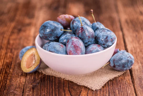 Holztisch mit Pflaumen, selektiver Fokus — Stockfoto