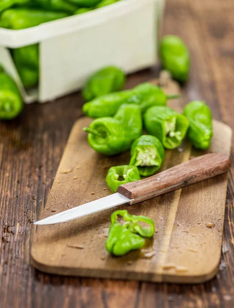 Holztisch mit rohen Pimientos, selektiver Fokus — Stockfoto