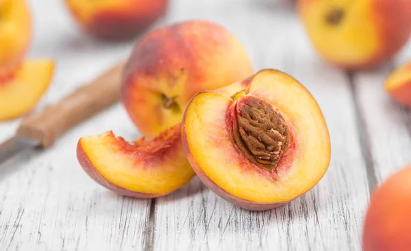 Perziken op een oud houten tafel — Stockfoto