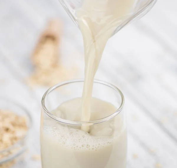 Mesa de madera vieja con leche de avena fresca (primer plano; selectivo f — Foto de Stock