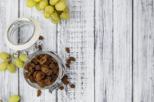 Portie verse rozijnen op een oude houten tafel — Stockfoto