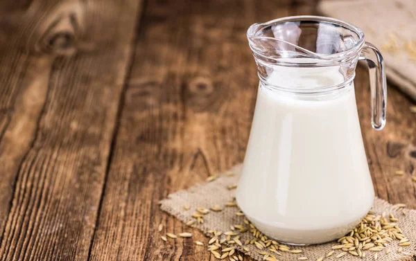 Mesa de madera vieja con leche de avena fresca (primer plano; selectivo f — Foto de Stock