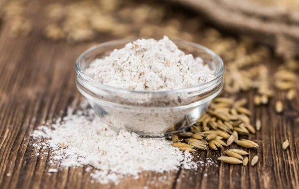 Vecchio tavolo in legno con farina d'avena fresca (primo piano; selettivo — Foto Stock