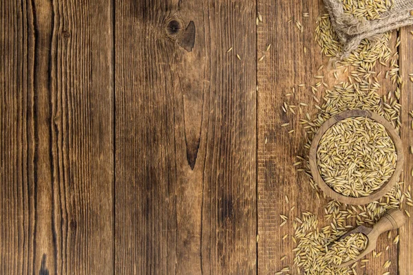 Mesa de madera vintage con avena (enfoque selectivo; plano de primer plano ) —  Fotos de Stock