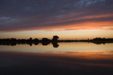 Gün batımında suda bulutların yansıması