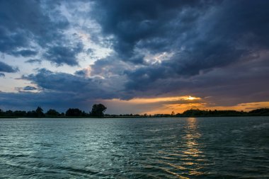 Gölde gün batımında renkli bulutlar