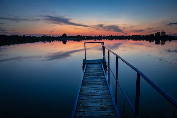 Jetty op een rustig meer en zonsondergang, 's avonds schoonheid uitzicht — Stockfoto