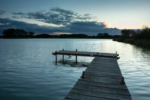 Jetty op een rustig meer en wolken, 's avonds uitzicht — Stockfoto