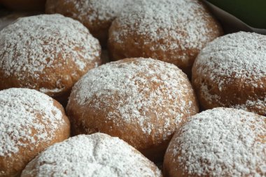 Taze yuvarlak çörekler üzerine şeker serpilmiş, yakın plan.