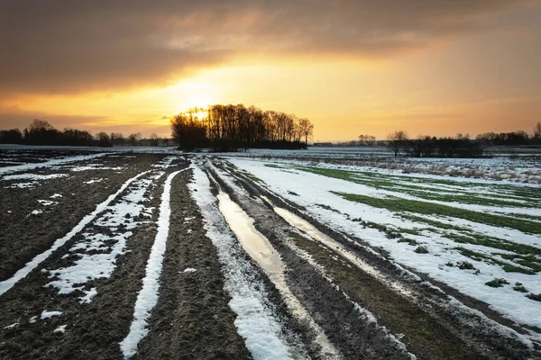 空のフィールド 日没と暗い雲の最後の雪 — ストック写真