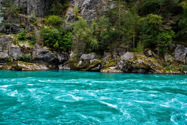 Eau turquoise d'une rivière avec des rochers, des falaises et des arbres en arrière-plan — Photo