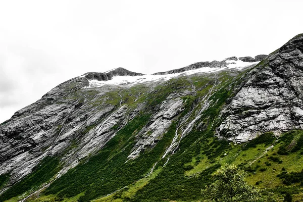 Dağ ve şelaleler kar ve Norveç'te yeşil çim kaplı