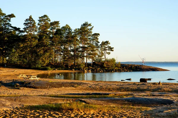 Güzel bir plaj ve İsveç'te sahilinde ağaçlar. Lake Vaenern, bütün alan gündoğumu aydınlatır.
