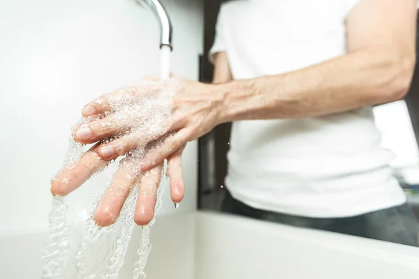 Man washing his hands sanitizing clean