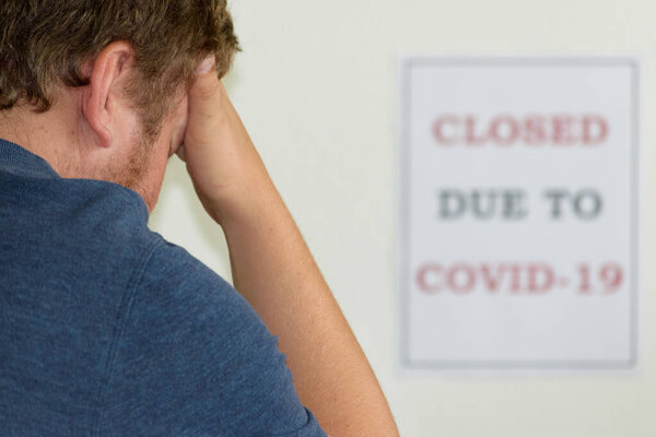 Stress and anxiety: a young man with his head in his hands during the covid-19 pandemic