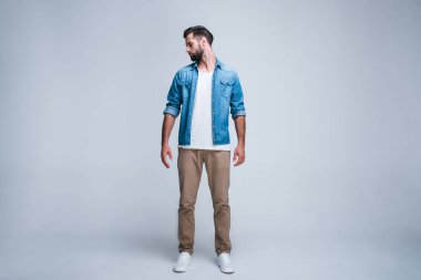 Detaylara dikkat. Yakışıklı genç adam onun omuz whilestanding beyaz bir arka plana dayanır bakarak tam uzunlukta