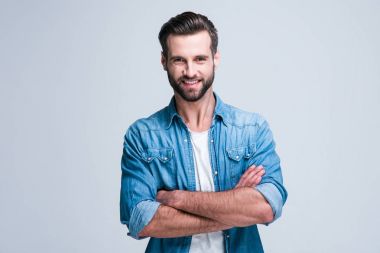 Gülümsemesi sever misin? Gülümseyerek kameraya bakıyor ve beyaz arka plan karşı duran armscrossed tutmak yakışıklı delikanlı
