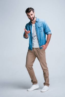 Belki sen? Sizi işaret ve gülümseme whilestanding beyaz arka plan ile kameraya bakarak yakışıklı delikanlı