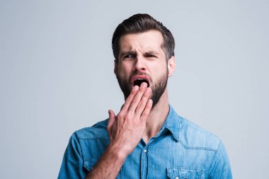 Bıkkın ve uykulu. Beyazlara karşı suç işliyor arka plan ayakta iken uykulu seyir yakışıklı genç adam portresi