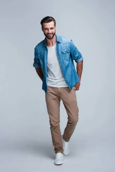 Modern öğrenci. Kameraya gülümse whilestanding beyaz arka plan ile seyir yakışıklı genç adam tam uzunlukta