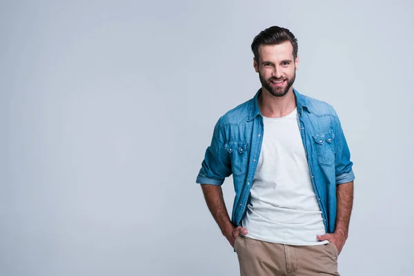 Bu gülümseme katlanıyorsun? Kameraya gülümse whilestanding beyaz arka plan ile seyir yakışıklı genç