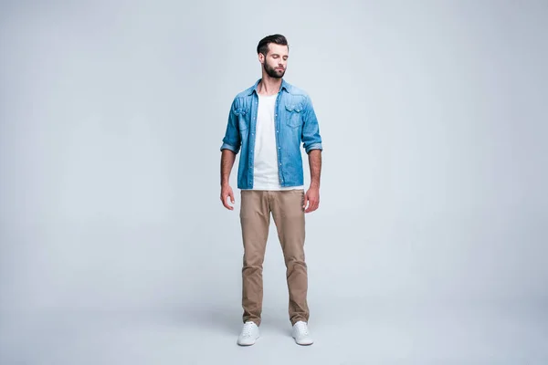 Burada ne varmış? Yakışıklı genç adam onun omuz whilestanding beyaz bir arka plana dayanır bakarak tam uzunlukta