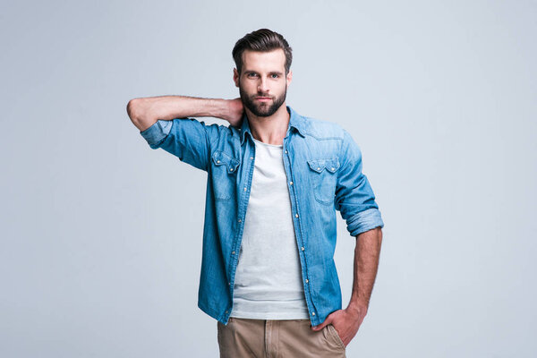 Can you stand this look? Handsome young man looking at camera while standing againstwhite background