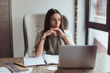 İş yerinde küçük dinlenme. Güzel genç işkadını ofis masasında otururken dalgın bakıyor