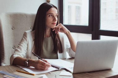 Onun yeni iş planlaması. Güzel genç işkadını ather Ofis Masası otururken dalgın bakıyor
