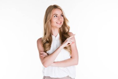 Buraya bak! Güzel genç kadın uzak duran beyaz arka plan karşı gülümseme ile işaret